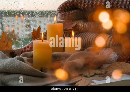 Hallo Herbst, wir feiern die Herbstferien im gemütlichen Haus auf dem Fenstersill Hygge Atmosphäre Thanksgiving Blätter, Gewürze und Kerze o Stockfoto