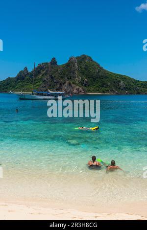 Touristen, die das wunderschöne, klare türkisfarbene Wasser von Monuriki oder die verlorene Insel Mamanuca, Fidschi genießen Stockfoto