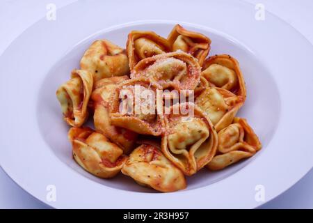 Italienische Tortelloni mit Tomatensauce und Parmigiano reggiano. Stockfoto
