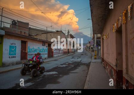 23. Mai 2023, Mexiko, San Nicolás de los Ranchos: Die Bewohner fahren ein Quad, während der Vulkan Popocatepetl im Hintergrund Asche, Dampf und Gas emittiert. Popocatépetl ist einer der aktivsten Vulkane in Mexiko. Seit Tagen gibt es Asche, Dampf und Gas aus. Die Experten gingen jedoch davon aus, dass die vulkanische Aktivität begrenzt sein wird, wie von der Behörde für Katastrophenschutz berichtet wurde. Foto: Celacanto/ Stockfoto