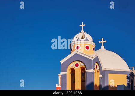 Katholische Kirche von Saint Stylianos gegen einen schönen blauen Himmel auf Santorini, Griechenland - Domes, bunt Stockfoto