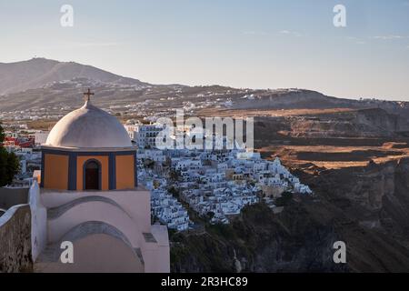 Panoramablick aus der Vogelperspektive auf das Dorf Fira und die katholische Kirche St. Stylianos auf Santorini, Griechenland - traditionelles Weißes Haus Stockfoto