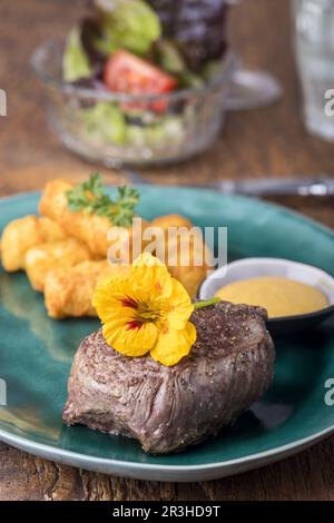 Steak mit Kroketten auf Holz Stockfoto