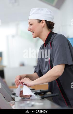 Ladenbesitzer, der einen Kunden in seinem Lebensmittelgeschäft bedient Stockfoto