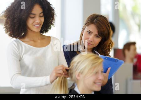 Lehrer helfen den Studenten Ausbildung Friseure zu werden Stockfoto