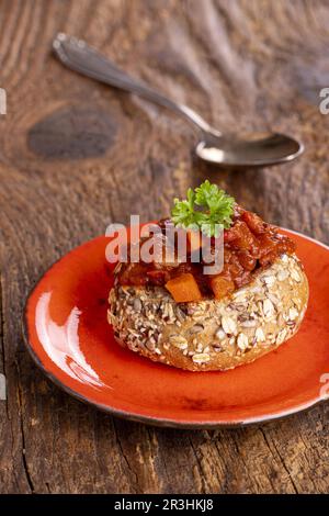 Gulaschsuppe in Brot auf dunklem Holz Stockfoto