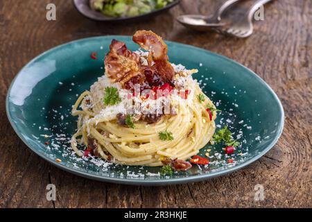 Spaghetti Carbonara mit Salat auf Holz Stockfoto