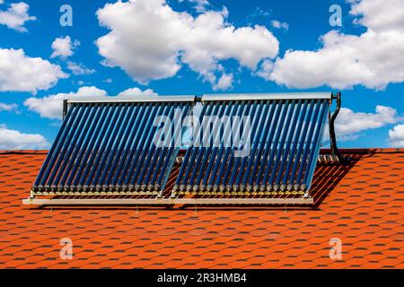 Auf dem Dach eines Wohnhauses installierter solarbetriebener Warmwasserbereiter Stockfoto