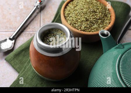 Calabash, Bombilla, Schüssel mit Teeblättern und Teekanne auf einem gefliesten Tisch, Nahaufnahme Stockfoto