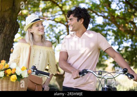 Ein junges Paar mit Fahrrad steht im Park Stockfoto