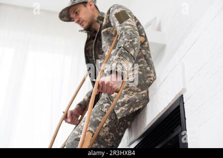 Soldat in Khaki-Militäruniform auf Krücken Stockfoto