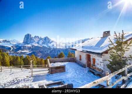 Hoch gelegene Berghütte vor einem Panorama schneebedeckter Gipfel Stockfoto