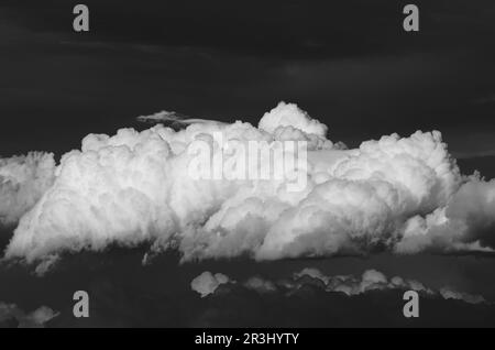 Schwarz-weiße Kumuluswolken am dunklen Himmel von Sizilien, Italien Stockfoto