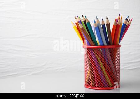 Viele bunte Bleistifte im Halter auf weißem Hintergrund, Platz für Text Stockfoto