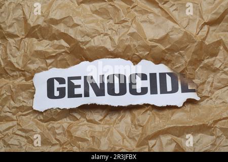 Verbrannte Karte mit dem Wort Genozid auf zerknittertem Papier, Draufsicht Stockfoto