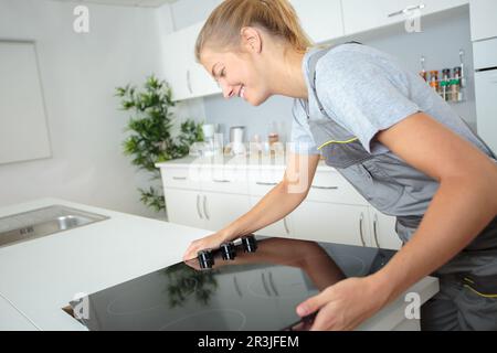 Frau Einbau Herd in der Küche Stockfoto
