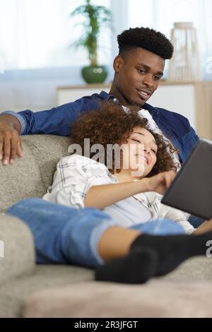 Glückliches Paar mit Tablet auf dem Sofa Stockfoto