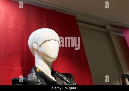 Kopf einer weiblichen Schaufensterpuppe vor rotem Hintergrund in einem Schaufenster in Colmar in Frankreich Stockfoto