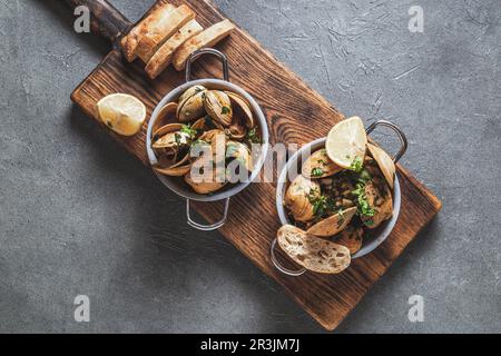 Zwei Pfanne mit Muscheln in Weißwein mit Kräutern. Draufsicht Stockfoto