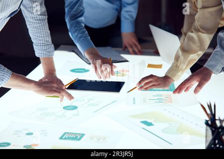 Ingenieure treffen sich im Technologieforschungslabor: Ingenieure, Wissenschaftler und Entwickler trafen sich um einen beleuchteten Konferenztisch. Inspektion Stockfoto