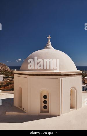 Wunderschöne kleine orthodoxe Kirche mit weißer Kuppel und farbenfrohem Glockenturm auf der Terrasse - Emporio, Santorin, Griechenland Stockfoto