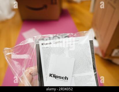 New York, USA - 18. April 2023: Handlesehandbücher moderner Klipsch Reference Bücherregallautsprecher mit kräftigen Bässen und klaren Höhen, ausgepackt in Nahaufnahme für professionelle Audiogeräte Jamo-Logo, da es zur gleichen Gruppe gehört - Lieferbox von amazon Stockfoto