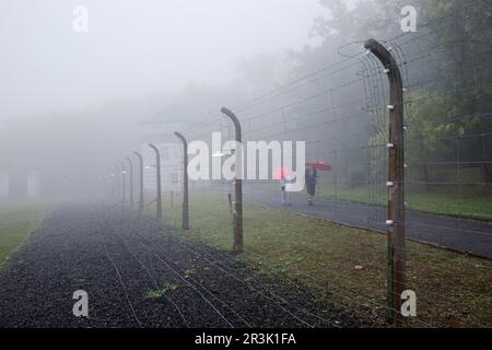 Umgebauter Zaun mit Menschen im Nebel im KZ Buchenwald, Weimar Stockfoto