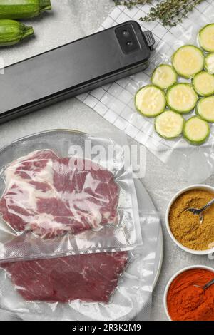 Flache Laienzusammensetzung verschiedener Lebensmittel, Gewürze und Versiegelung für Vakuumverpackungen auf dem Tisch Stockfoto