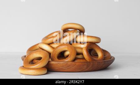 Teller mit leckeren trockenen Bagels (Sushki) auf weißem, strukturiertem Tisch Stockfoto