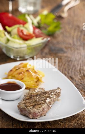 Steak auf einem Teller mit Kartoffelgratin Stockfoto