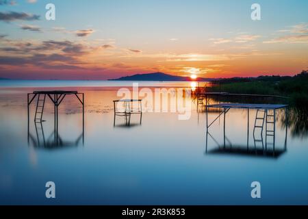 Sonnenaufgang über dem Plattensee in Ungarn mit Stadt und Berg Fenyves Stockfoto