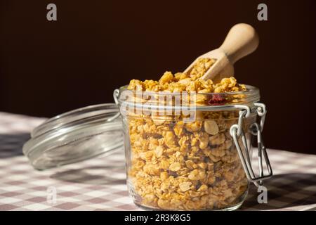 Hausgemachtes Müsli mit Nüssen und Samen in einem Öko-Glasbehälter. Gesunder Snack zum Frühstück. Müsli aus Haferflocken, Rosinen, Honig, Cranberr Stockfoto