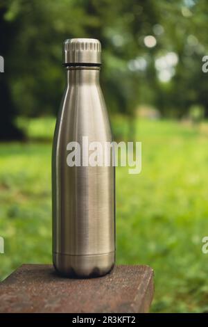 Wasserflasche. Wiederverwendbare Wärmflasche aus Stahl auf Holzbank. Nachhaltiger Lebensstil. Ohne Plastik, ohne Abfall, ohne Leben. Geh Stockfoto