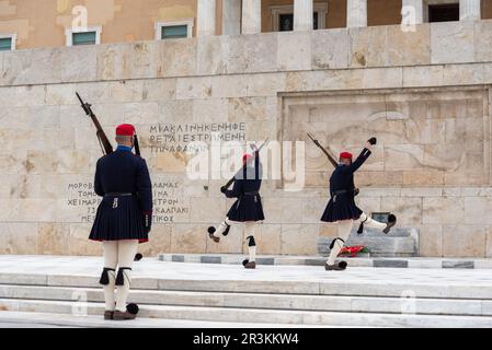 Text an der Wand und ein Bett bleibt für Unbekannte in griechischen und griechischen Evzone-Soldaten in traditionellen Kostümen leer Stockfoto