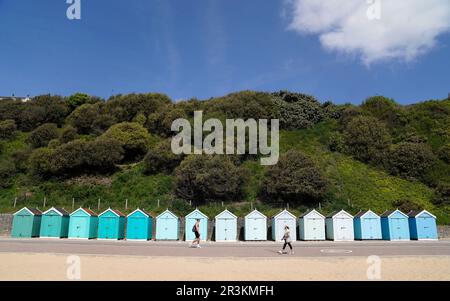 Die Leute kommen an Strandhütten am Bournemouth Beach in Dorset vorbei. Bilddatum: Mittwoch, 24. Mai 2023. Stockfoto