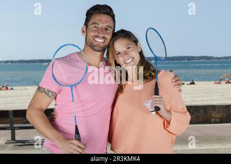 Ein Paar, das sich posiert, nachdem er draußen Badminton gespielt hat Stockfoto