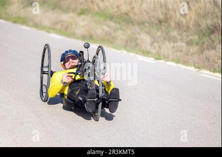 Sportler mit Behinderungstraining mit seinem Handbike auf der Rennstrecke. Stockfoto