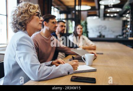 Geschäftsleute, die eine Konferenz in einem Büro abhalten. Gruppe von Geschäftsleuten, die zusammen in einem Sitzungssaal sitzen. Team von Geschäftsleuten Stockfoto
