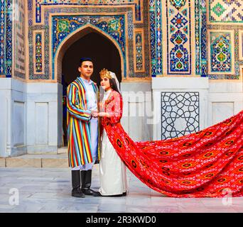 Samarkand, Usbekistan - 18. April 2021: Braut und Bräutigam in traditionellen usbekischen Kleidern in der antiken Stadt Registan, Samarkand in Usbekistan Stockfoto