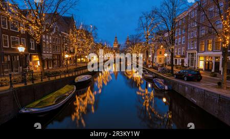 Amsterdamer Kanäle mit Weihnachtslichtern im Dezember, Grachtenhistorisches Zentrum Amsterdam bei Nacht Stockfoto