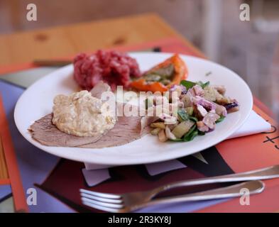 Eine köstliche Vorspeise aus Piedmont. Steak Tartare, Carpaccio, gefüllte Paprika und Salat Stockfoto