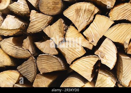 Wand aus Brennholz, Hintergrund aus trocken gehacktem Brennholz. Holzhintergrund. Natürliche Textur. Weltweite Energiekrise. Heizung mit Holz Stockfoto