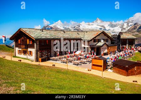 ZERMATT, SCHWEIZ - 16. JULI 2019: Seilbahnstation und Straßencafé in der Nähe von Zermatt im Kanton Wallis Stockfoto