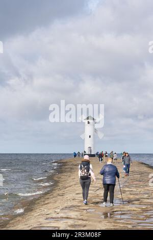 Urlauber am Muhlenbake, dem Wahrzeichen von Swinoujscie an der polnischen Ostseeküste Stockfoto