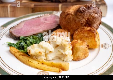 Ein traditionelles englisches Abendessen mit Braten. Serviert mit Rinderstriploin, Bratkartoffeln, Blumenkohl, Pastinaken, Kohl und einem Yorkshire Pudding Stockfoto