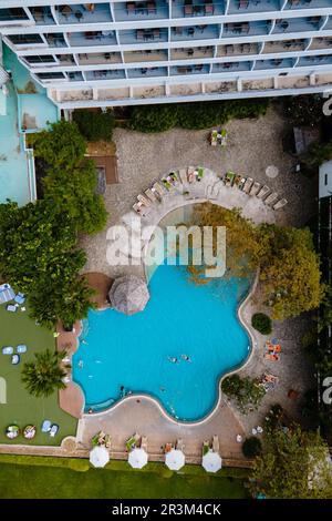 Liegestühle am Swimmingpool mit Sonnenschirmen Stockfoto