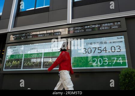 (230524) -- TOKIO, 24. Mai 2023 (Xinhua) -- Eine Frau kommt an einem Bildschirm vorbei, auf dem Börseninformationen in Tokio, Japan, 24. Mai 2023 angezeigt werden. Der japanische Benchmark-Nikkei-Aktienindex schloss am unteren Mittwoch, da die Investoren nach den jüngsten Gewinnen des Marktes weiterhin Gewinne einhielten, während die Bedenken hinsichtlich der US-Schuldenobergrenze und des Potenzials eines beispiellosen Zahlungsausfalls andauerten. Der 225 ausgegebene Nikkei-Aktiendurchschnitt fiel um 275,09 Punkte oder 0,89 Prozent vom Dienstag bis zum Abschluss des Tages um 30.682,68 Uhr. Der umfassendere Topix-Index verlor dagegen 9,09 Punkte oder 0,42 Prozent, um bei 2.152,40 abzuschließen. Xi Stockfoto