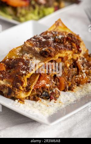 Portion Lasagne auf einem weißen Teller Stockfoto