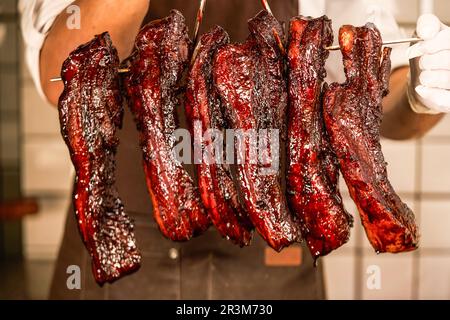 Char Siu - Honig-Barbecue-Schweinebraten auf einem Holztisch - Chinesisches gegrilltes Schweinefleisch aus nächster Nähe, chinesisches siu mei Stockfoto