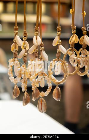 Schmuck zeigt Meeresdekorationen auf dem Straßenmarkt. Frau wählt Dekorationen auf dem lokalen Straßenmarkt in Danzig, Polen. Weiblich Stockfoto